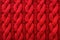 Textile background for design with close-up view of soft, knitted texture in warm wool, showcasing an intricate pattern with red