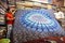 Textile factory owner with his assistant showing handmade printed cotton mandala sheets