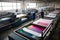A textile printing factory with workers operating digital textile printers to produce printed fabrics and textiles