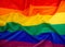 textile rainbow flag with waves, symbol of freedom of choice of lesbians, gays, bisexuals
