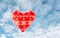 Textile red heart with snow flakes with cloudscape in the backg