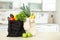 Textile shopping bags full of  and fruits on table in kitchen. Space for text