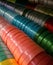 Textural silk ribbons on a shelf in a store. Homemade concept. Colorful ribbons arranged in rows in needlework store.