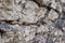 Texture background. Antique flagstone natural stone wall with selective shallow focus at the beginning and blurred distal part