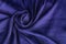 Texture, background, pattern. Fabric silk satin color cobalt, classic blue royal. Drape material in a flower shape