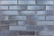 The texture of a brick wall with a ceramic facing brick is dark gray-brown. Modern decoration of cottages and houses. Image for