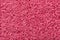 The texture of the carpet in pink color close-up. Thick pile material