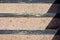 Texture of a concrete staircase with metal corners from above in bright sunlight