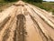 Texture of a dirty bad dirt road dirt road with puddles and clay drying mud with cracks and ruts. Off-road. The background