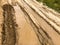 Texture of a dirty bad dirt road dirt road with puddles and clay drying mud with cracks and ruts. Off-road. The background