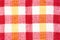 Texture of fabric with a bright checkered pattern. Christmas. Scrapbooking. Napkin, knitting, eyelets,