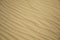 Texture of fine golden sand from a beach dune waved by the wind