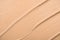 The texture of the foundation close-up, macro. A smear of beige liquid concealer. A sample of a nude cosmetic product for a
