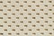 Texture of genuine geometric perforated genuine leather close-up, light cream paint color, background substrate