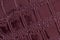 Texture of genuine leather close-up, embossed under the skin of reptile, burgundy color. For modern background