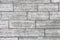 The texture of a gray stone wall made of rectangular marble blocks