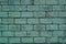 The texture of the greenish brick shabby wall