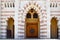 Texture of large beautiful wooden doors of an Arab Muslim Islamic temple made of white and brown bricks with arches for prayers. T