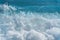 Texture Light blue surface of raging sea water with white foam and wave pattern.The azure surface of the ocean. Waves break at the