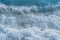 Texture Light blue surface of raging sea water with white foam and wave pattern.The azure surface of the ocean. Waves break at the