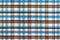 The texture of linen fabric in a large cage of blue, brown and white. Scottish tailoring material. Checkered fabric