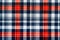 The texture of linen fabric in a large cage of blue, red and white. Scottish tailoring material. Checkered fabric