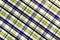 The texture of linen fabric in a large cage of blue, yellow and white. Scottish tailoring material. Checkered fabric