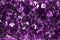 The texture of a mineral precious or semiprecious amethyst stone, shimmering with purple shades, is close-up
