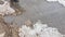 The texture of a muddy puddle with snow, ice and debris, spring snowmelt, outdoor stream