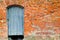 The texture of the old ancient medieval antique solid wooden thick door against the background of a stone wall of red brick