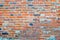 The texture of the old ancient medieval antique sturdy stone peeling scratched wall of rectangular red orange bright brick