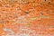 The texture of the old ancient medieval antique sturdy stone peeling scratched wall of rectangular red orange bright brick