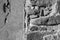 Texture of old stone wall with collapsed plaster. Background of shabby building surface. Destroyed wall with fallen plaster.