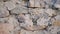 Texture of old stones of various forms with seams. Close up of shabby masonry. Stone wall from uneven different ancient