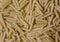 Texture of pasta macaroni from a solid wheat variety light sepia. Italian Macaroni Pasta raw food background or texture