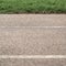 Texture paved road with markings on the background of green grass. Part of the photo is in blur.