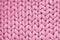 Texture of pink wool big knit blanket. Large knitting. Plaid merino wool. Top view