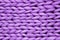 Texture of purple knit blanket. Large knitting. Plaid merino wool. Top view
