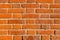 The texture of red antique brick. Background of old red brick wall texture with deterioration from age. The brick wall is lit by