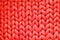 Texture of red wool big knit blanket. Large knitting. Plaid merino wool. Top view