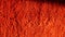 Texture of a red woolen carpet illuminated by lateral sunbeams. Close-up macro