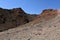 The texture of the rock of the ancient canyon, small bushes of grass and red breed