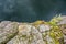 Texture of the rocky shore and dark grey water of a lake