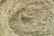 Texture of a round natural dried dry haystack of straw is a dry grass with spikelets and grass blades of brown yellow background