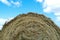 Texture round natural dried dry haystack straw dry grass village farm against a blue sky clouds Harvesting animal feed background
