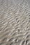 Texture of sand beach showing wave pattern and reef rock.