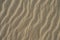 The texture of a sandy surface with natural waves formed by the winds