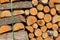 The texture of sawn firewood, tightly stacked to each other, close-up