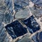 The texture of the sidewalk from large pieces of blue marble and granite tiles arranged in a chaotic manner with streaks of cement