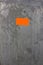 Texture of silvered rough and grunge metallic surface with a shiny orange sticker